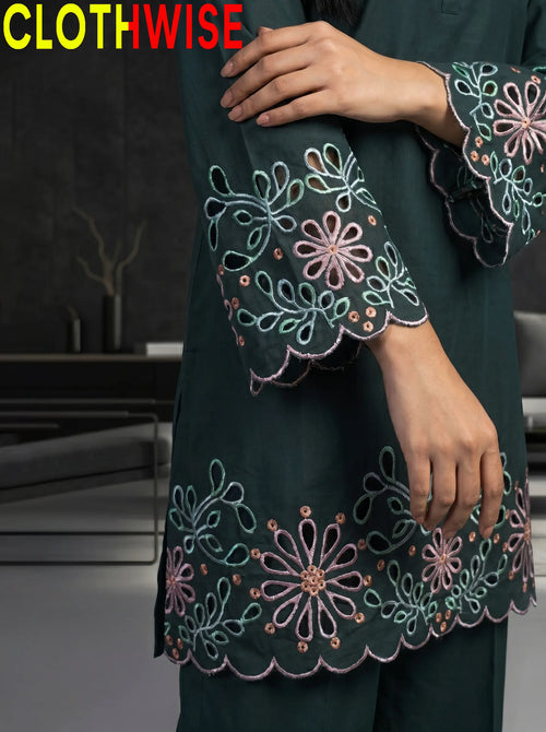 Dark green embroidered garment with floral patterns on a blurred indoor background