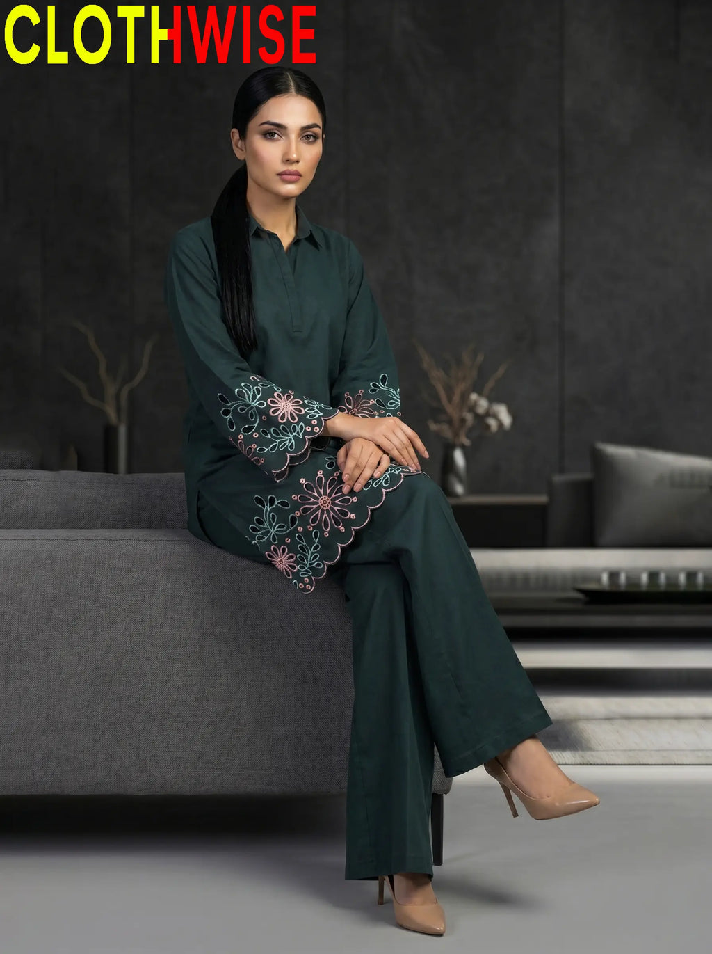 Woman wearing a dark green outfit with floral embroidery in a modern setting, branded 'ClothWise'.