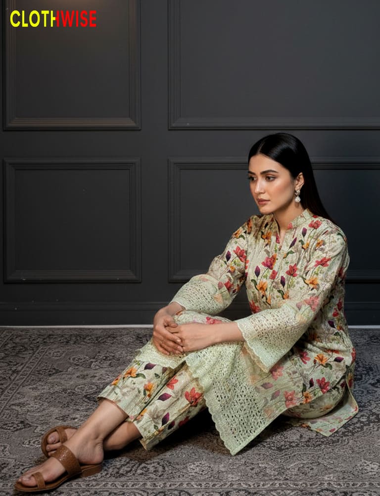 Woman wearing a floral outfit sitting on the floor with a dark wall background