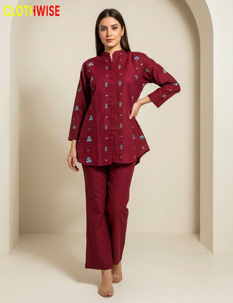 Woman wearing a maroon traditional outfit with embroidery in a neutral setting, branded 'Clothwise'.