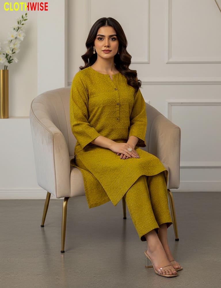 Woman in a green outfit sitting on a chair with a neutral background