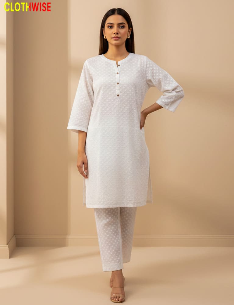 Woman wearing a white kurta with matching pants against a beige background