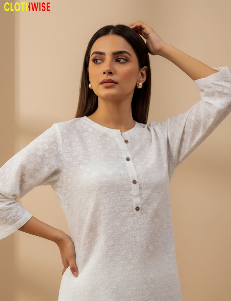 Woman wearing a white kurta with buttons on a beige background, with 'Clothewise' branding.