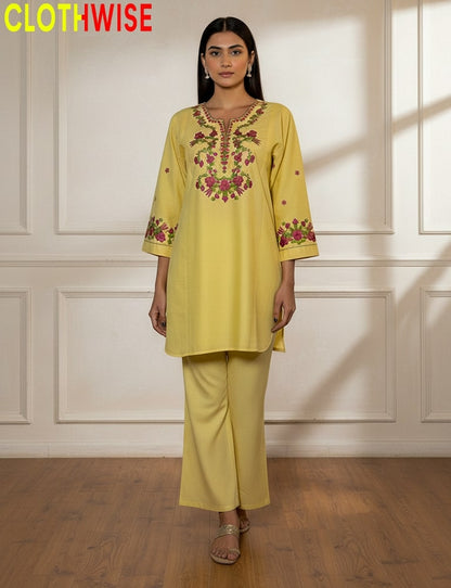 Woman wearing a yellow embroidered outfit with 'CLOTHWISE' branding.