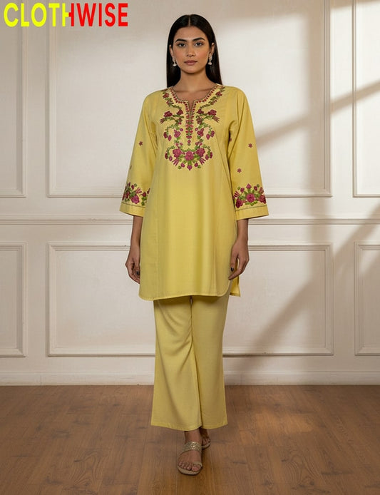 Woman wearing a yellow embroidered outfit with 'CLOTHWISE' branding.