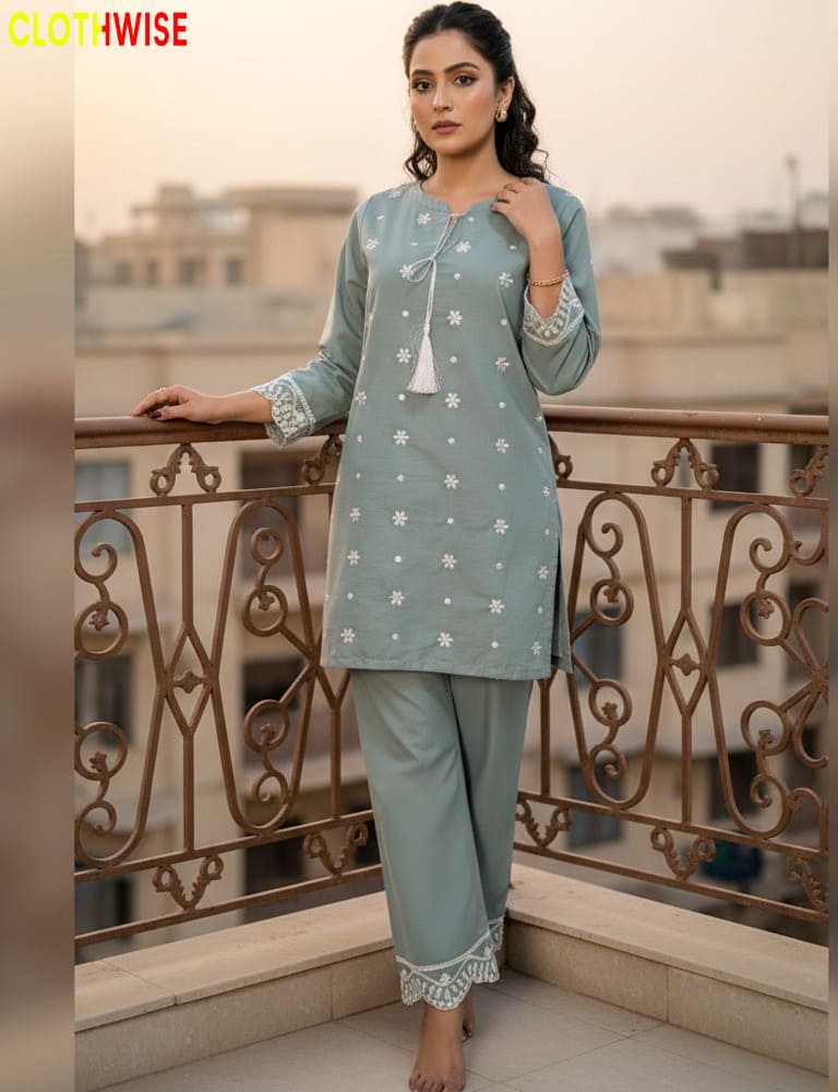 Woman in a icegreen traditional outfit standing on a balcony with a cityscape background.