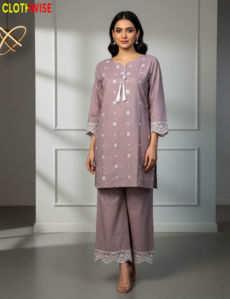 Woman wearing a lavender outfit with white floral patterns in a minimalistic setting.