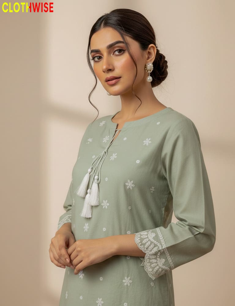 Woman wearing oatmeal kurta with white floral patterns and tassel details, with 'CLOTHWISE' branding.