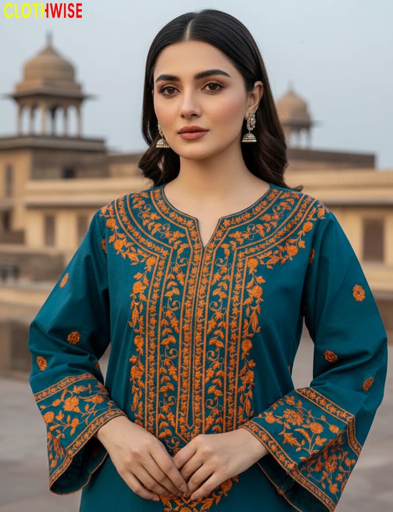 Woman wearing a teal and orange embroidered traditional outfit with a blurred architectural background.