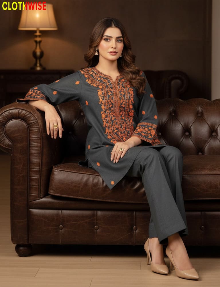 Woman sitting on a brown leather couch wearing a dark blue outfit with orange patterns.