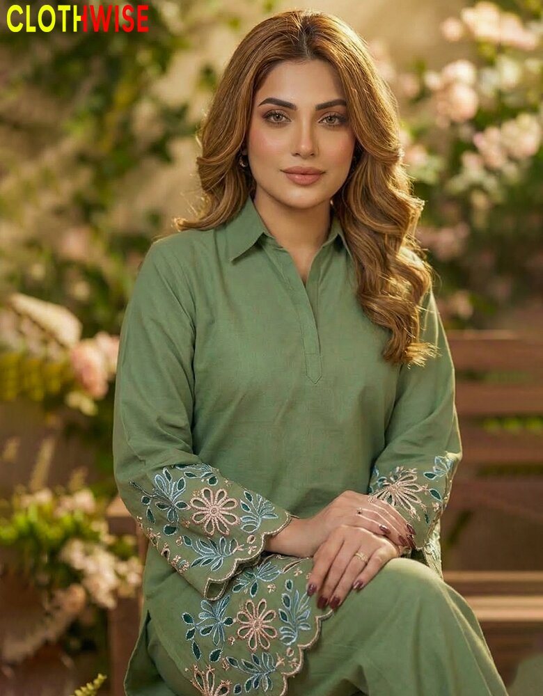 Woman wearing a green embroidered outfit with a blurred floral background