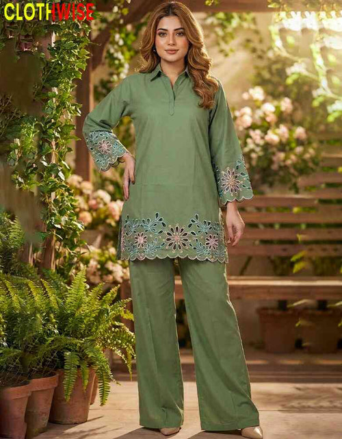 Woman wearing a green outfit with floral embroidery in an outdoor setting.