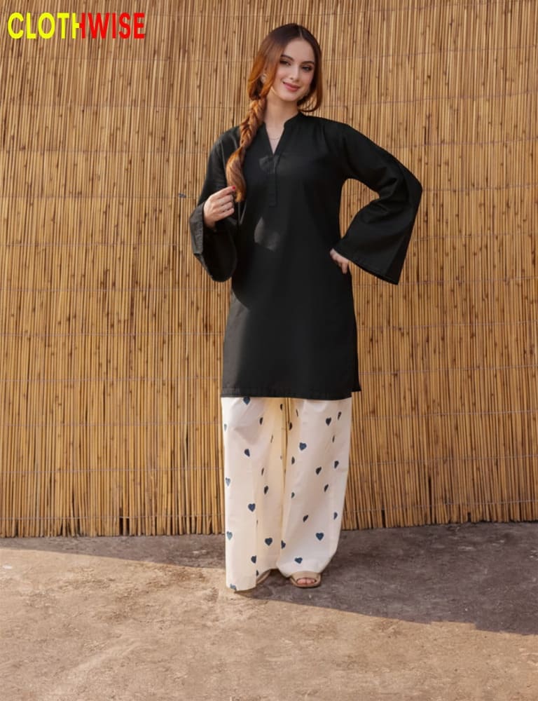 Woman wearing a black top and white pants with heart patterns against a wooden background, branded 'Clothwise'.