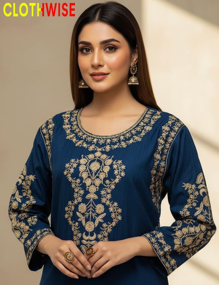 Woman wearing a blue embroidered top with gold details, standing against a neutral background with 'CLOTHWISE' branding.