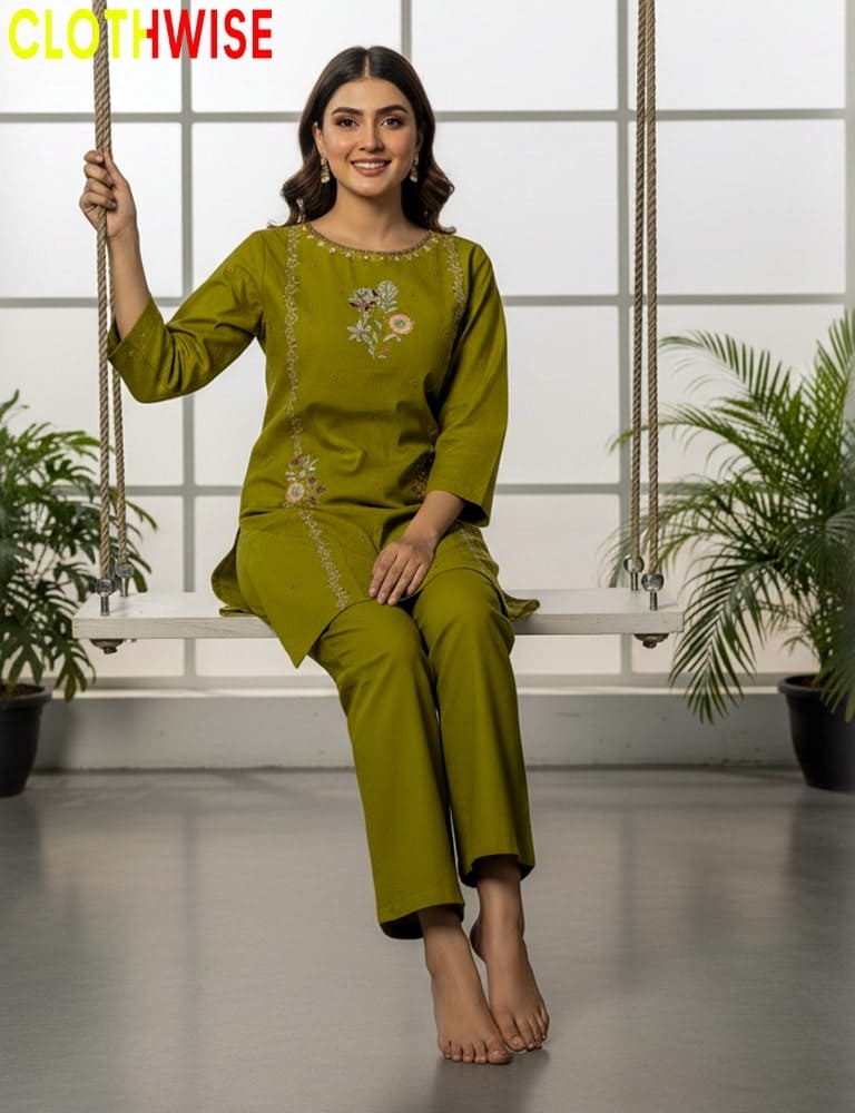Woman in a green traditional outfit sitting on a swing with plants in the background, brand 'CLOTHWISE' visible.