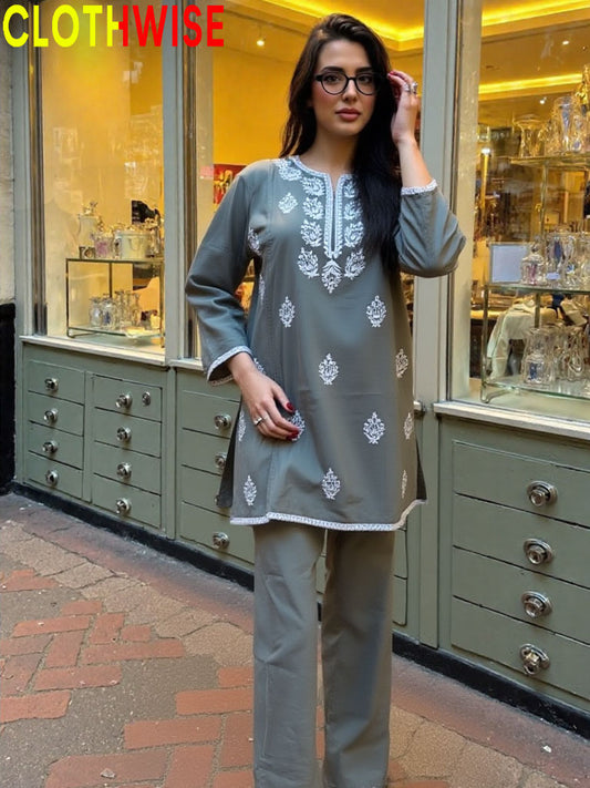 Woman in a gray embroidered outfit standing in front of a store with 'CLOTHWISE' branding.