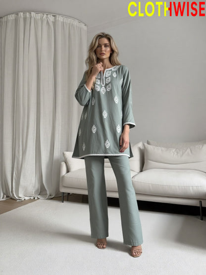 Woman wearing a gray outfit with floral patterns in a minimalistic room, with 'CLOTHWISE' branding.