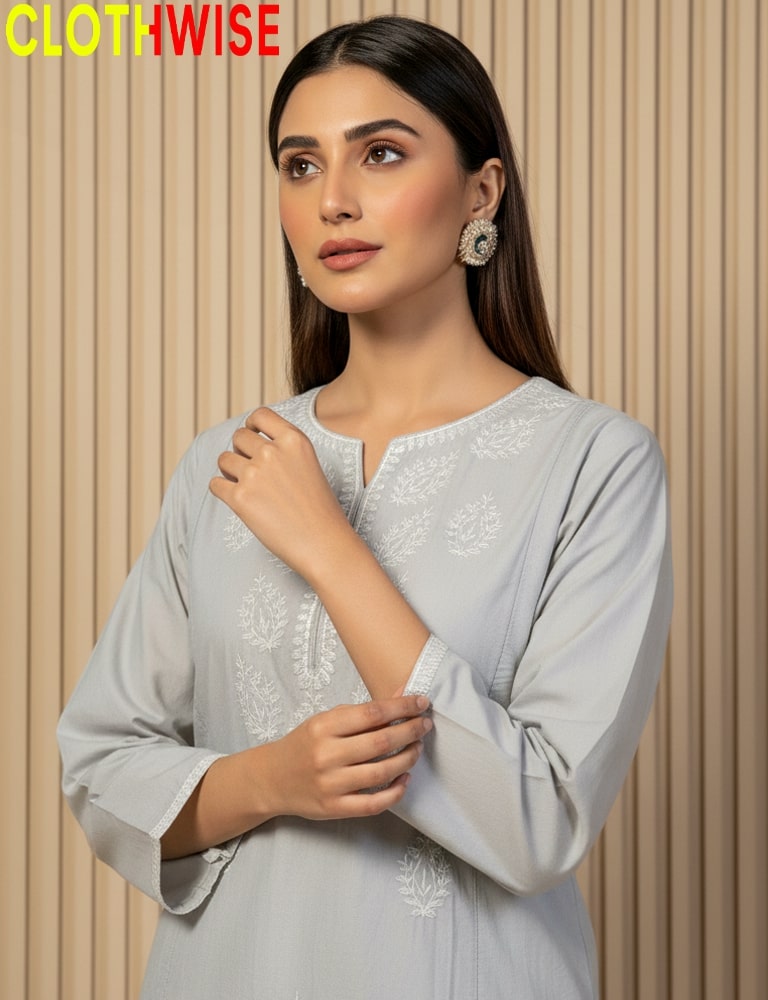 Woman wearing a light gray embroidered outfit with a beige background, branded 'CLOTHWISE'.