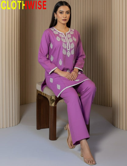 Woman wearing a purple embroidered outfit sitting on a wooden stool against a neutral background with 'CLOTHWISE' branding.