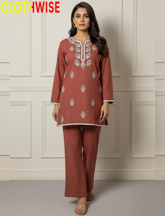 Woman wearing a rust-colored embroidered outfit with 'CLOTHWISE' branding.