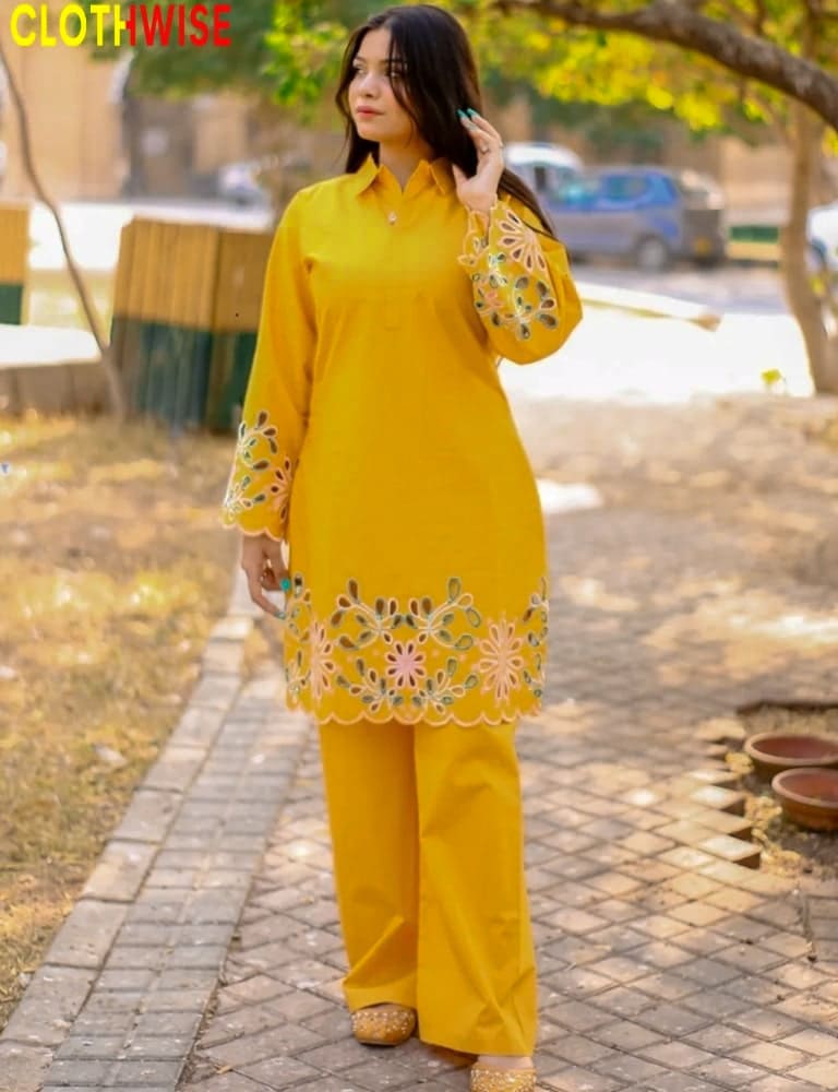 Woman wearing a yellow outfit with floral patterns outdoors.