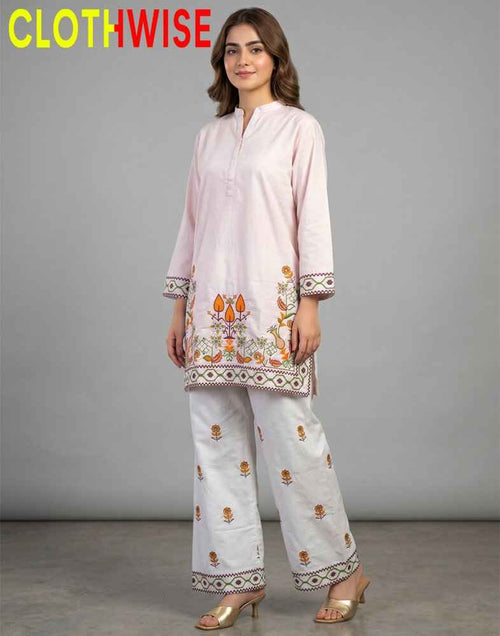 Woman wearing a light pink and white embroidered outfit with 'CLOTHWISE' branding.