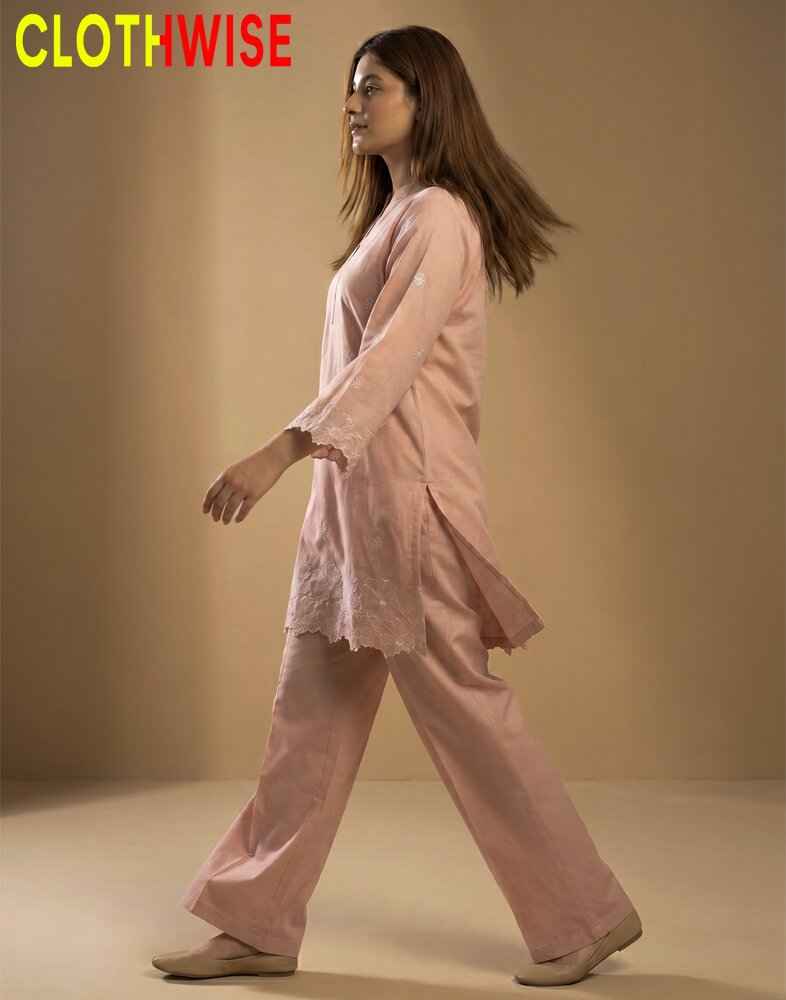 Woman wearing a pink outfit with 'Clothewise' branding on a beige background