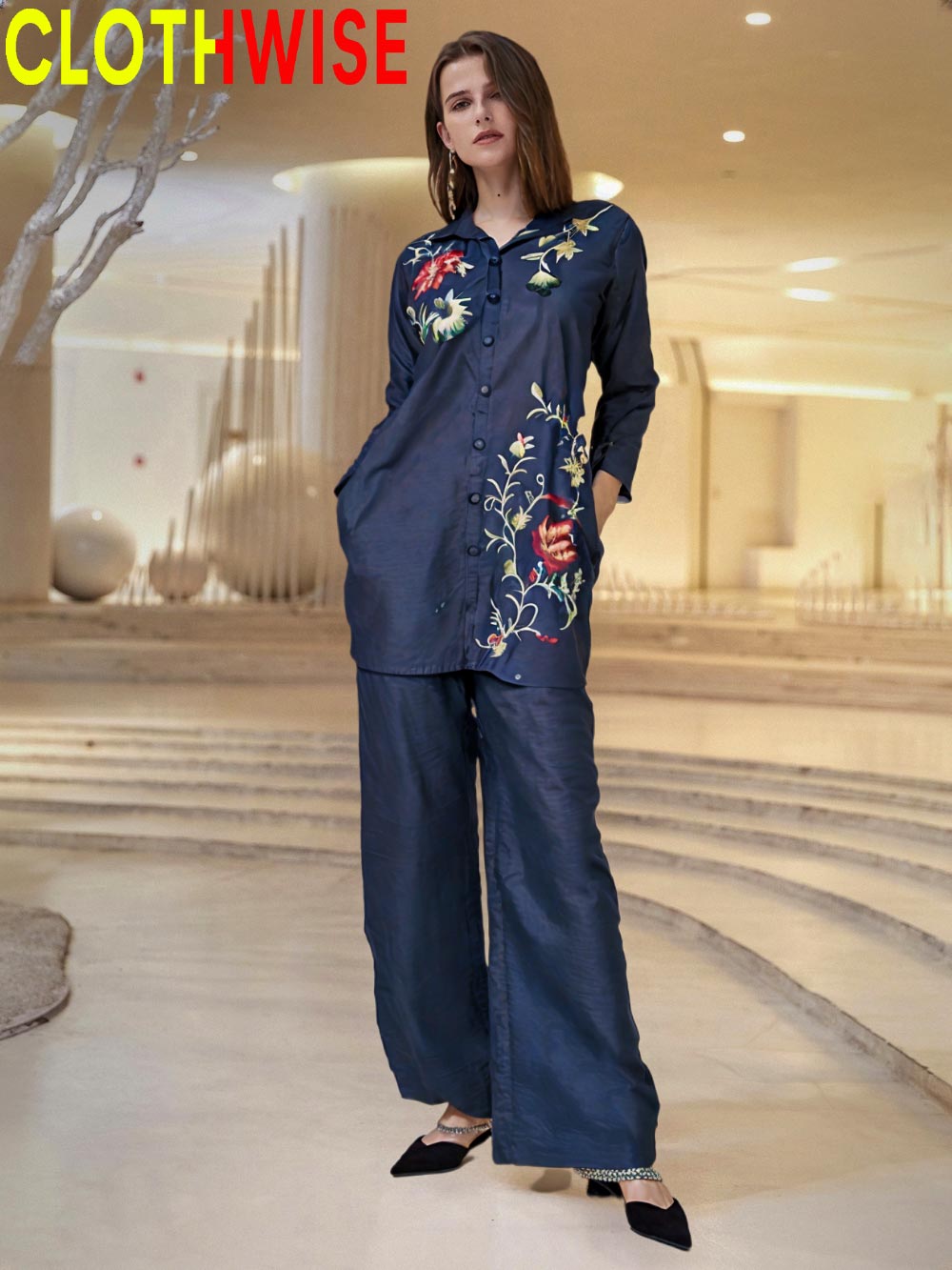 Woman wearing a navy blue embroidered outfit in an indoor setting with 'CLOTHWISE' branding.