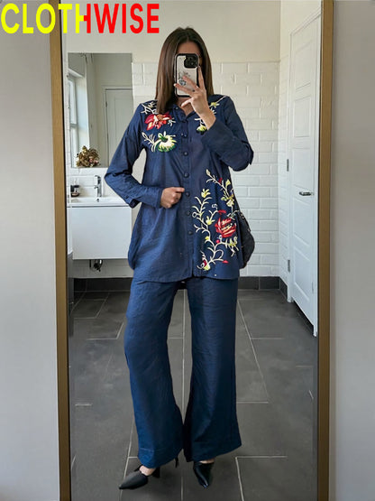 Person wearing a blue outfit with floral embroidery in a bathroom setting, with 'CLOTHWISE' branding.