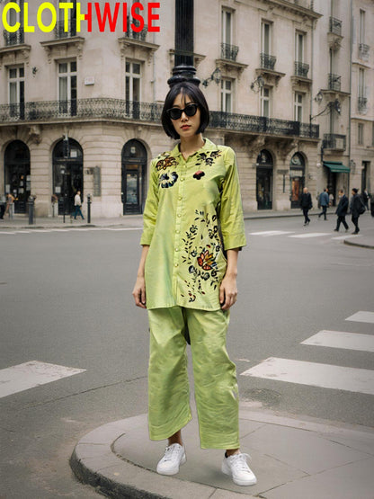 Person wearing a bright green outfit with floral patterns on a city street.