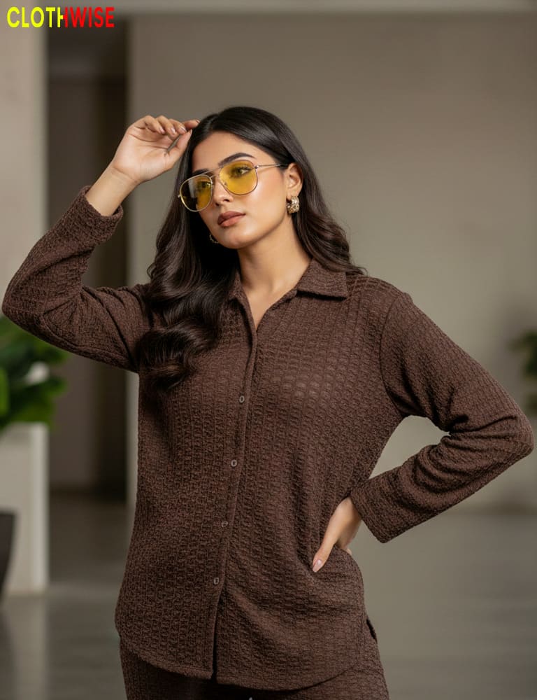 Woman wearing a brown textured shirt with sunglasses indoors