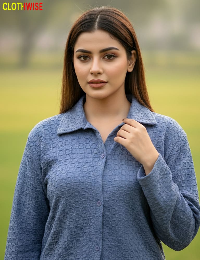 Woman wearing a blue textured shirt against a blurred green background