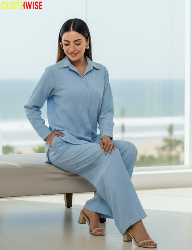 Woman in a light blue outfit sitting on a couch with a blurred background