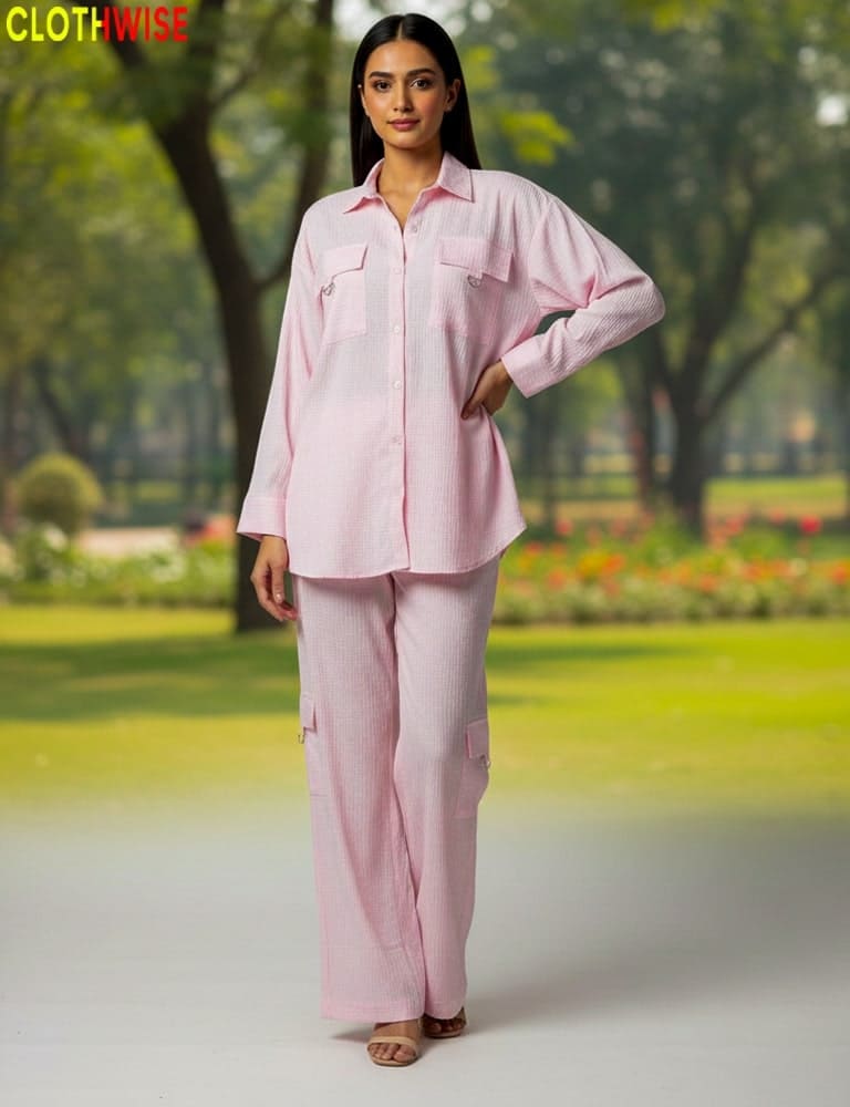 Woman wearing a pink outfit standing in a park with 'CLOTHWISE' branding.