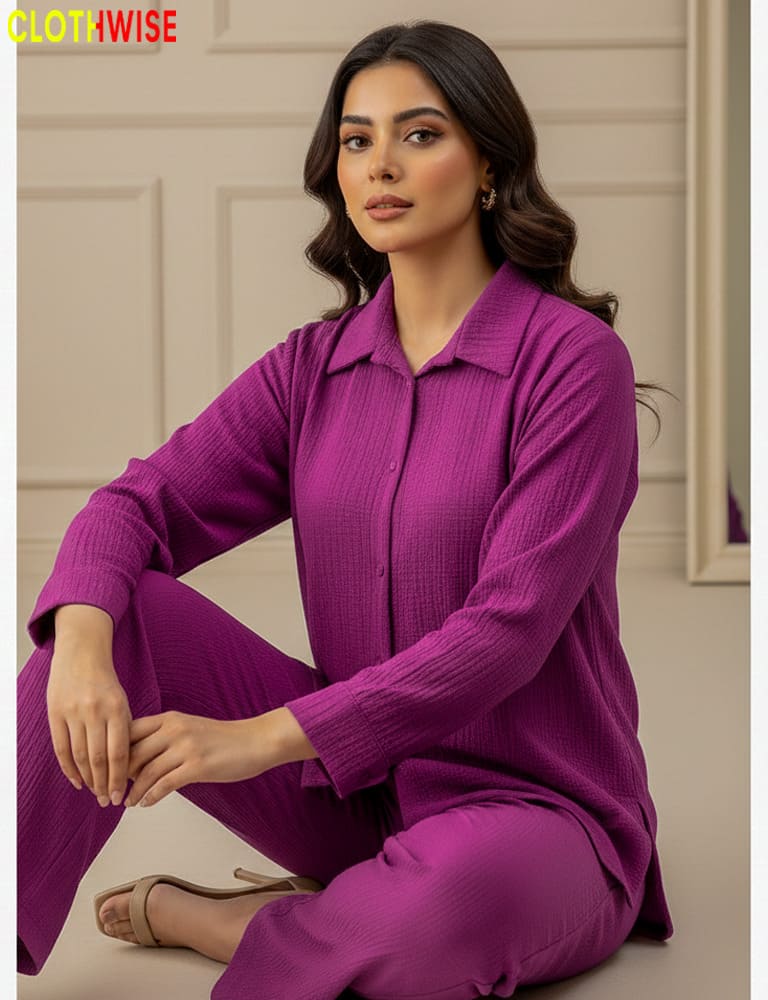 Woman wearing a purple outfit sitting on the floor with a neutral background