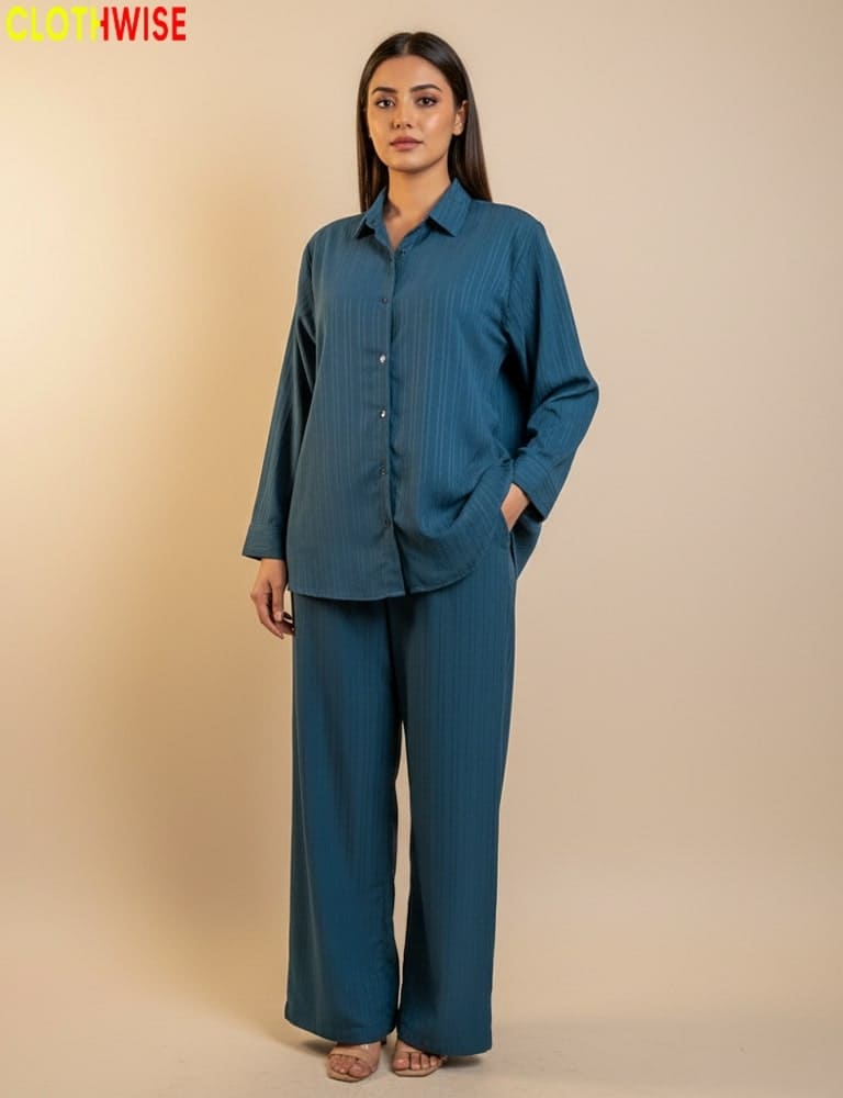 Woman wearing a teal outfit with a beige background