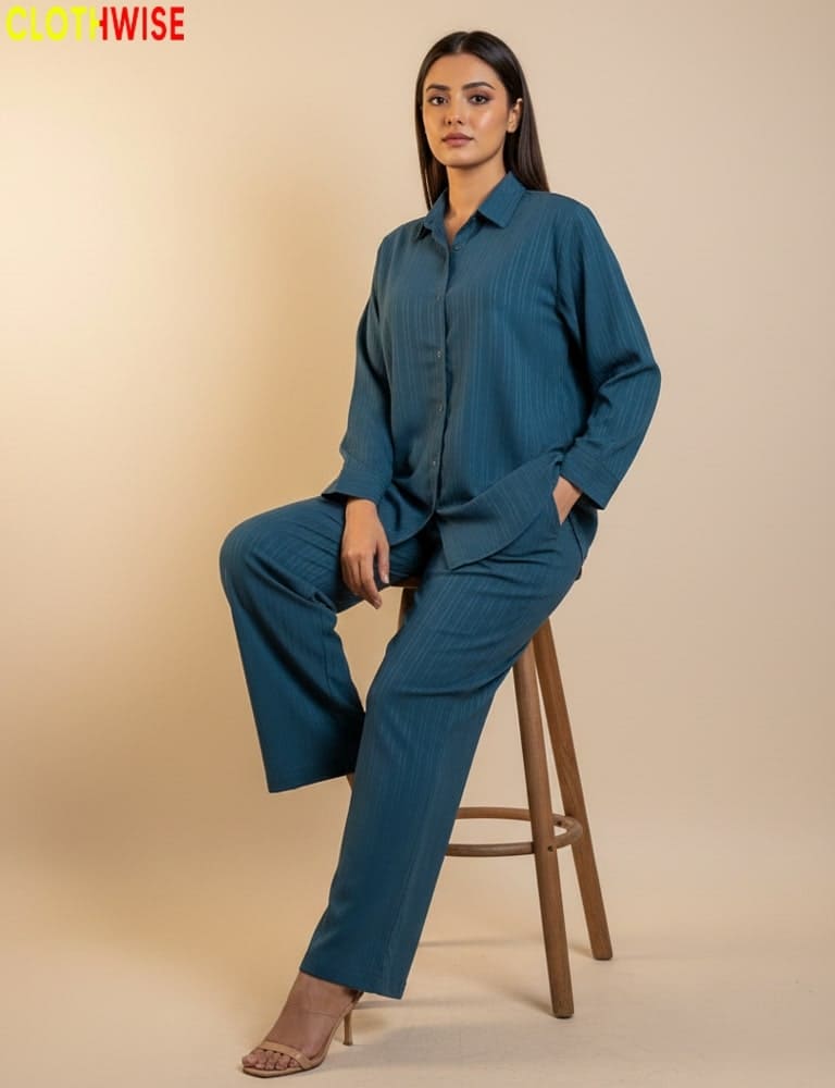 Woman wearing a teal outfit sitting on a wooden stool against a beige background, with 'Clothwise' branding.