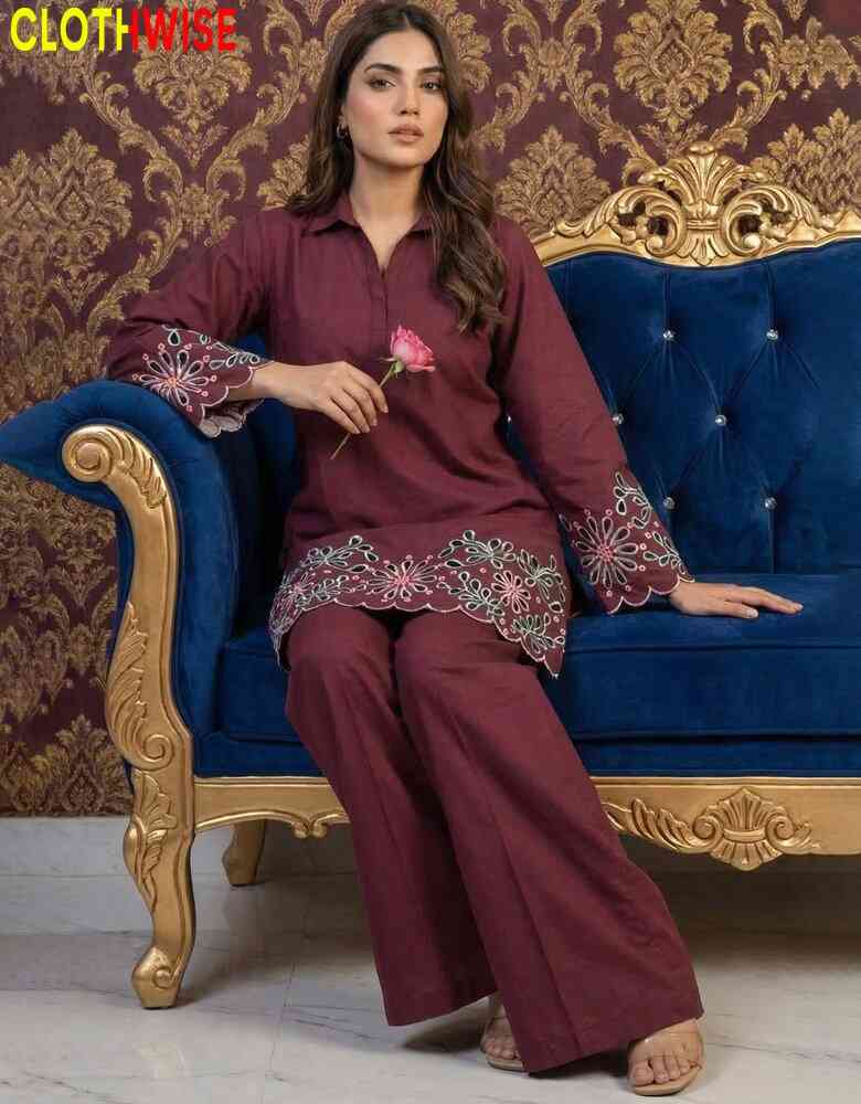 Woman in maroon embroidered outfit sitting on a blue and gold sofa, with 'CLOTHWISE' branding.