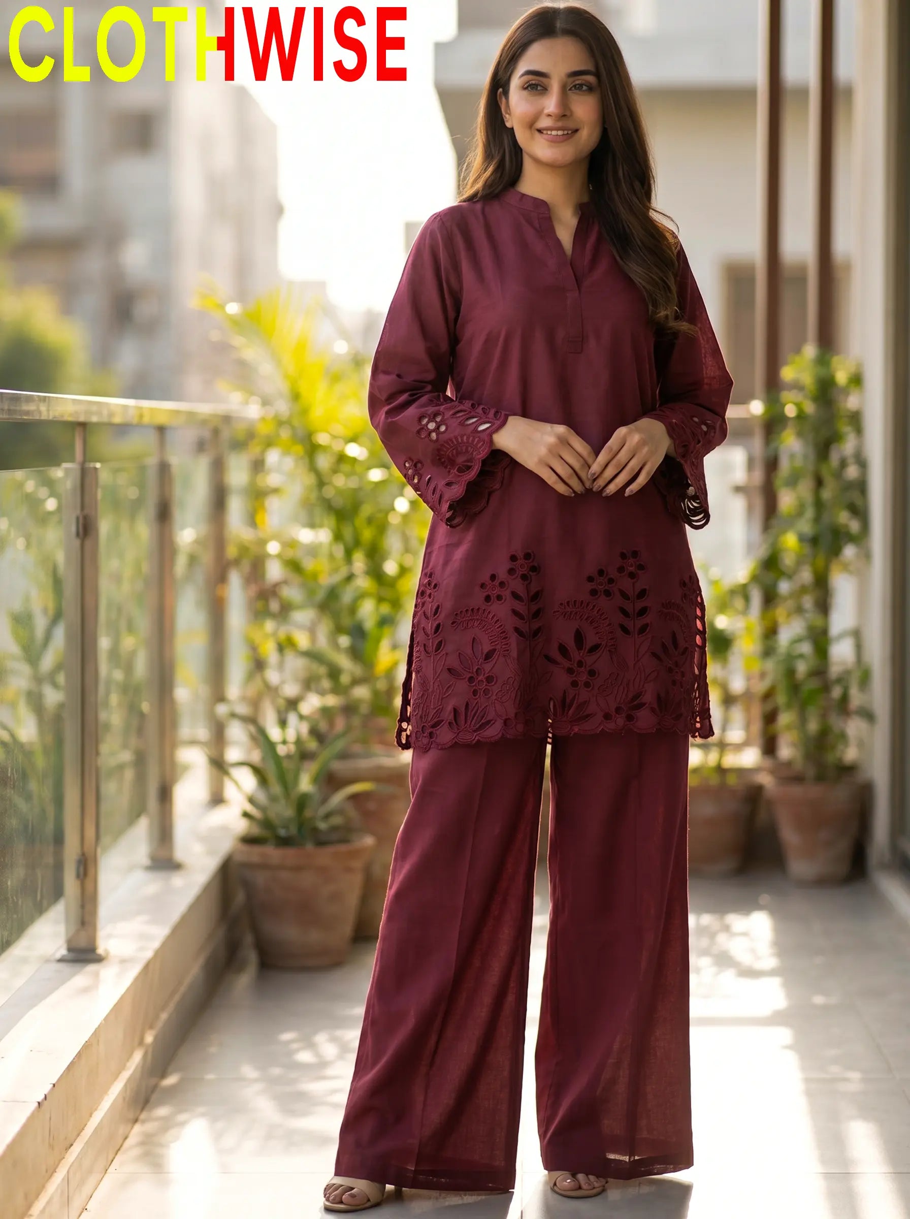Woman wearing a maroon outfit with floral patterns on a balcony with plants