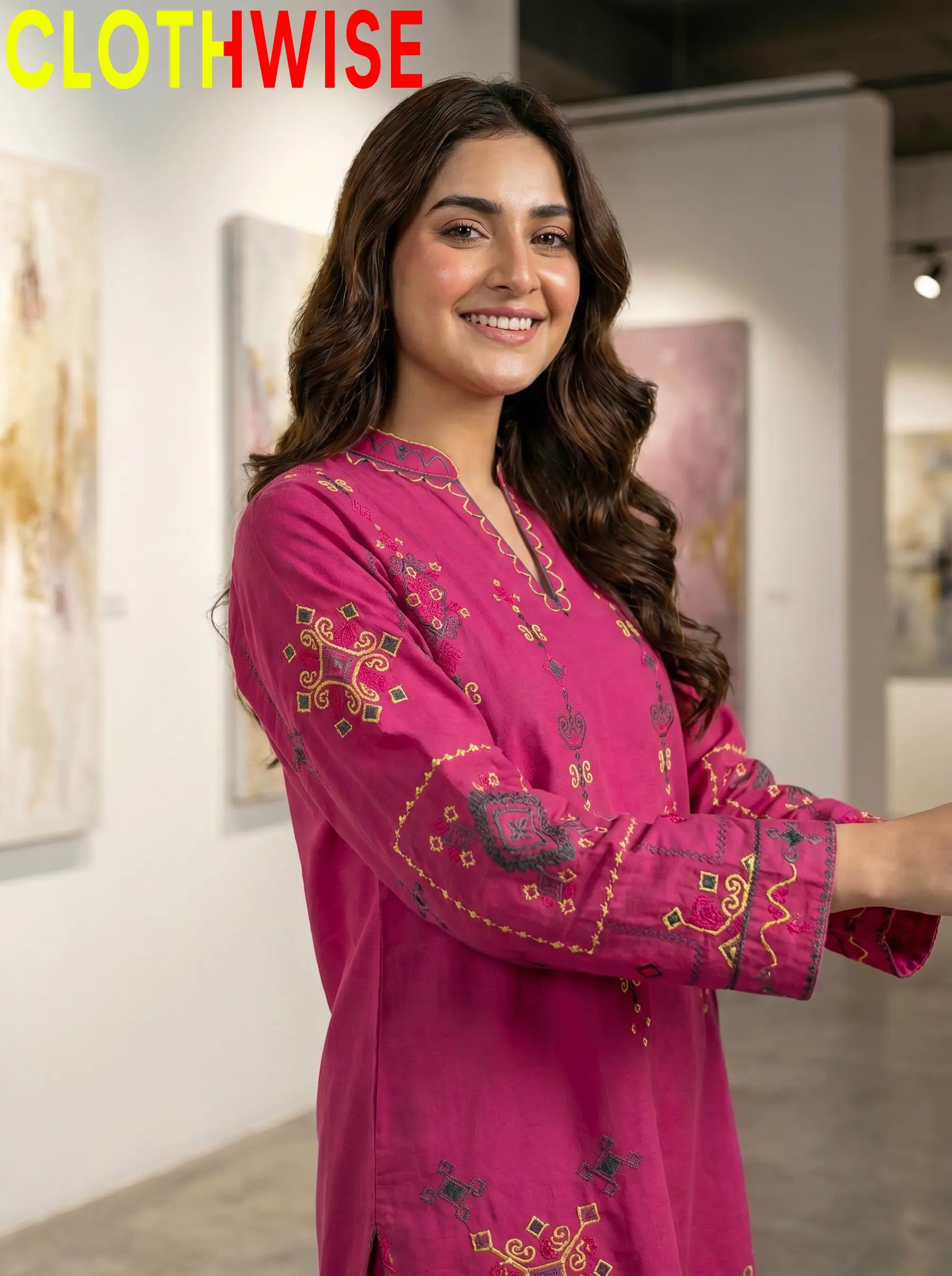 Woman wearing a pink embroidered traditional outfit with 'CLOTHWISE' branding.