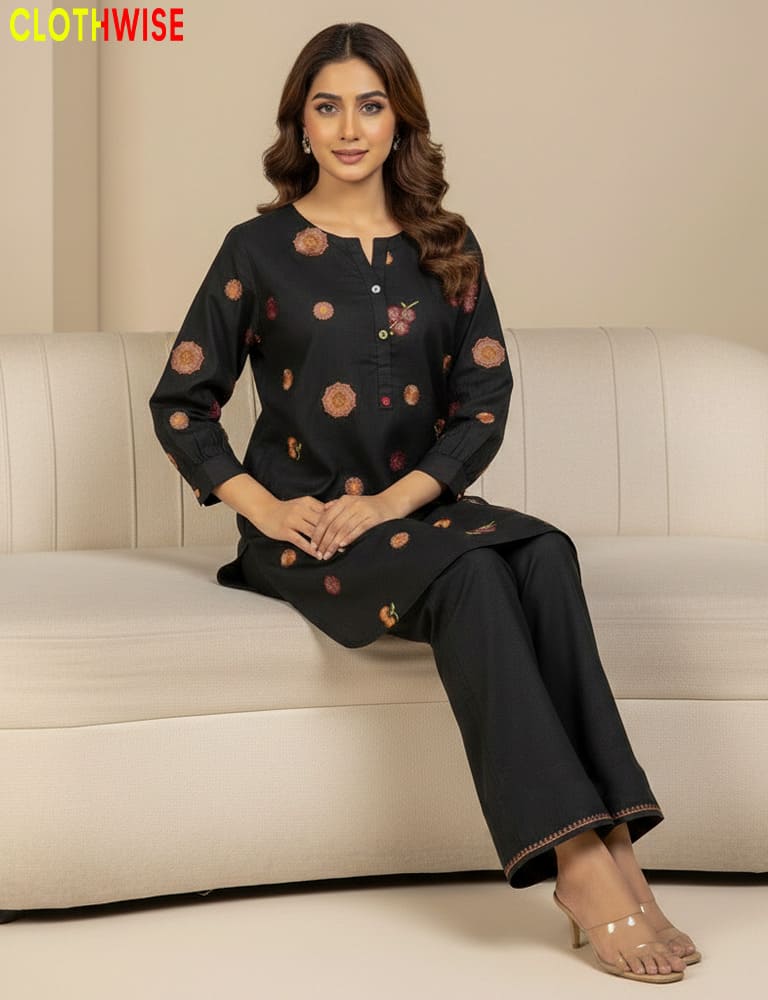 Woman wearing a black outfit with floral patterns sitting on a beige sofa, with 'CLOTHWISE' branding.