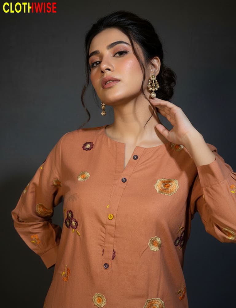 Woman wearing a brown embroidered top with 'ClothWise' branding.