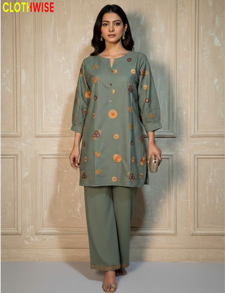 Woman wearing a green embroidered outfit with a neutral background