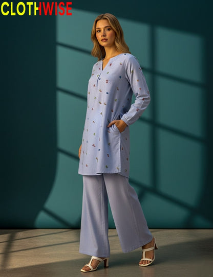 Woman wearing a light blue outfit with 'CLOTHWISE' branding against a teal wall.