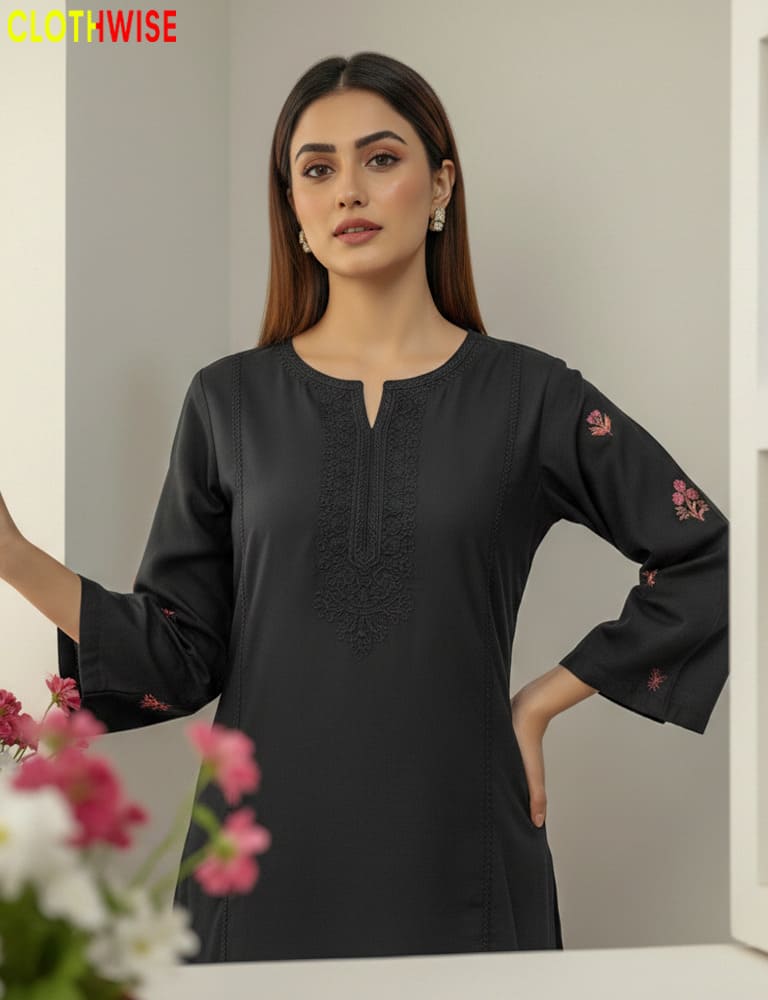 Woman wearing a black kurta with floral embroidery, standing against a neutral background.