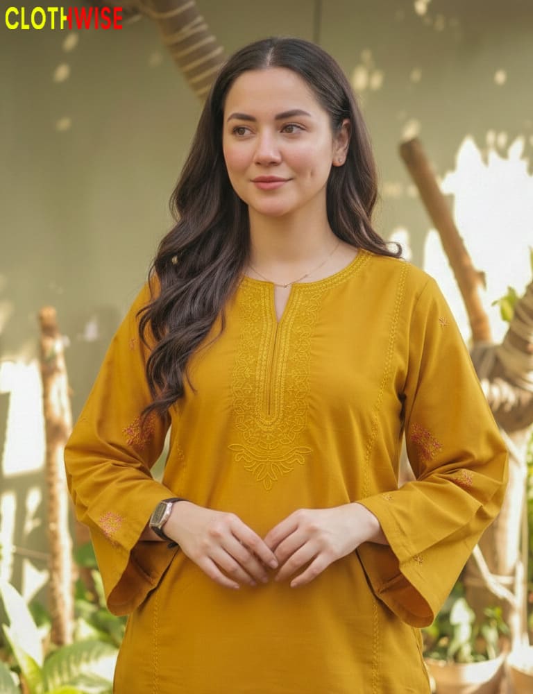 Woman wearing a mustard yellow top with a blurred natural background