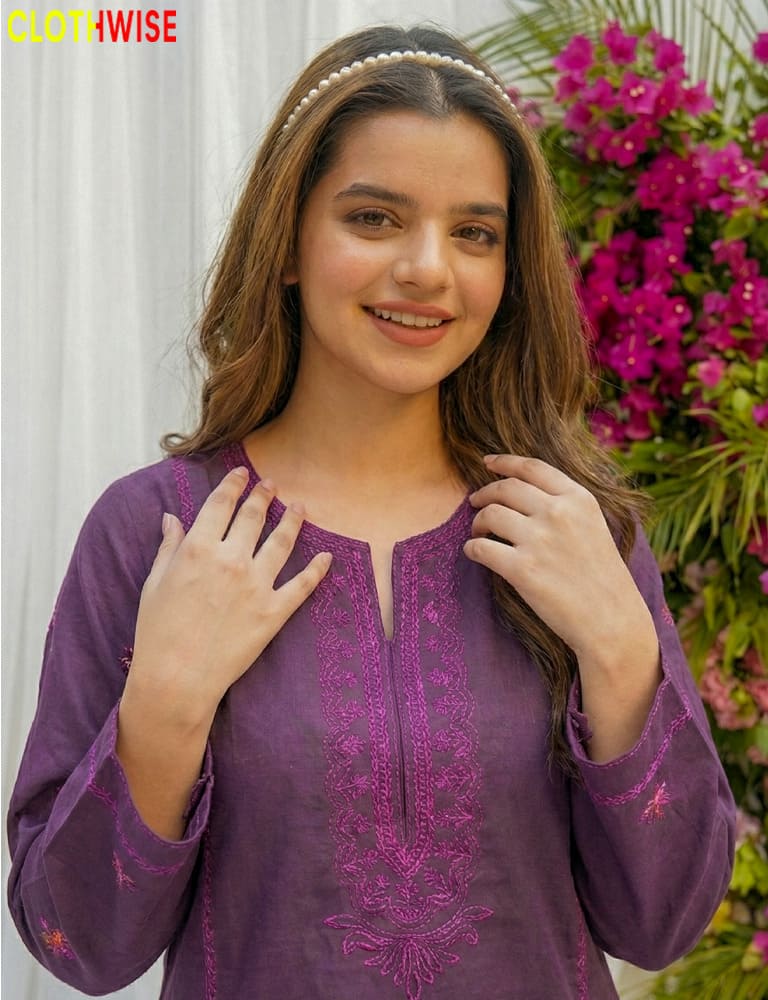Woman wearing a purple embroidered top with floral background