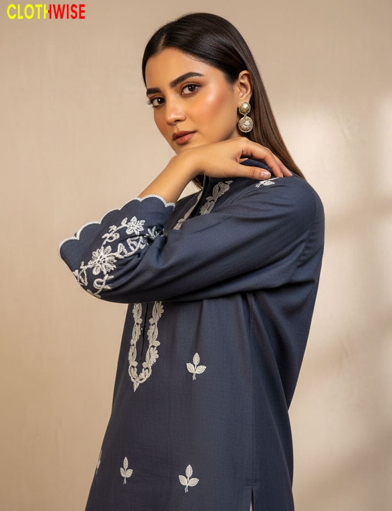 Woman wearing a navy blue embroidered outfit against a beige background