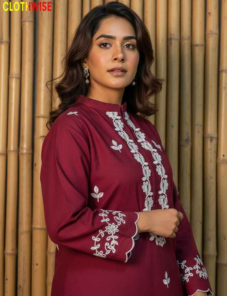 Woman wearing a maroon dress with white embroidery against a bamboo background