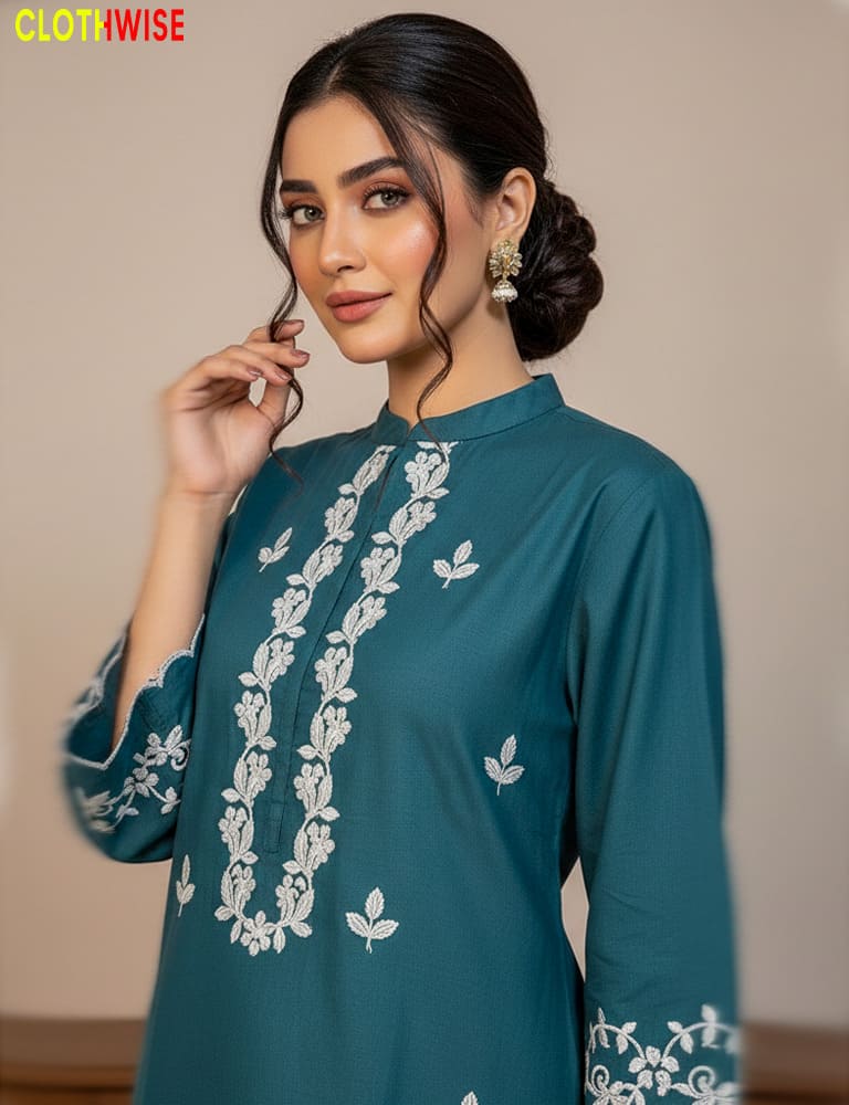 Woman wearing a teal kurta with white floral embroidery against a beige background